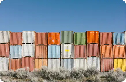Stacked multicolored shipping containers at a logistics yard