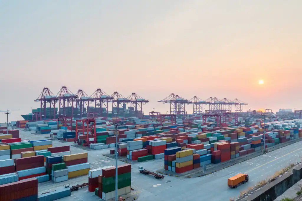 Port at dusk with stacked shipping containers and cranes for PayCargo Payments case study